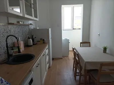 a kitchen with a sink and a table and a refrigerator at Sunrise home in Burgas City