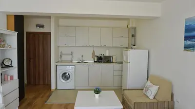 a kitchen with a refrigerator and a table in a room at Fortuna Cape B46 - Фортуна Кейп В46 in Byala