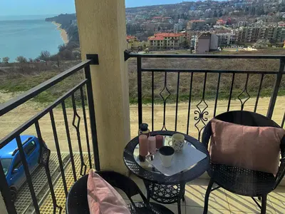 a table and chairs on a balcony with a view of the ocean at Fortuna Cape B46 - Фортуна Кейп В46 in Byala