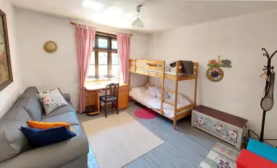 a living room with a couch and a bunk bed at Bulgarian country house near the sea in Banya