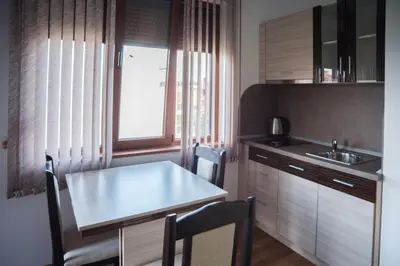 a kitchen with a table and chairs and a sink at Guest House Georgievi in Primorsko