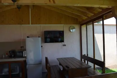 a kitchen with a wooden table and a refrigerator at Guest House Georgievi in Primorsko