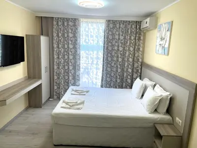 a hotel room with a bed and a television at Apart-Hotel Panorama Sea LUX in Primorsko