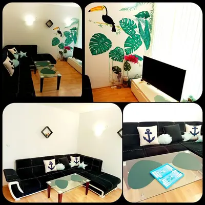 a living room with a black couch and a table at One Sunny Home in Sunny Beach in Sunny Beach