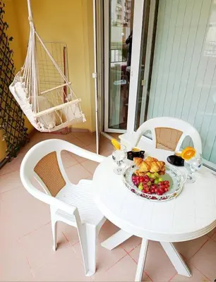 a white table and chairs with a plate of food on it at One Sunny Home in Sunny Beach in Sunny Beach