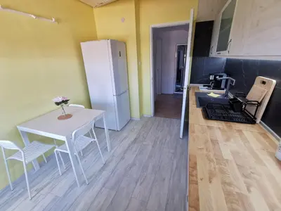 a kitchen and dining room with a white table and chairs at Апартамент Хармония ТОП Център в Стария Град in Pomorie