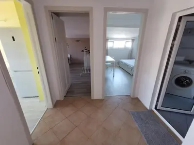 a hallway leading to a bedroom and a laundry room at Апартамент Хармония ТОП Център в Стария Град in Pomorie