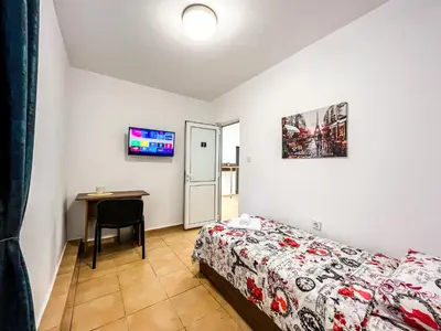 a small bedroom with a bed and a table at Centrino in Burgas City