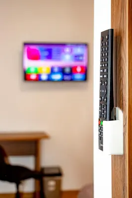 a television on a wall with a remote control at Centrino in Burgas City