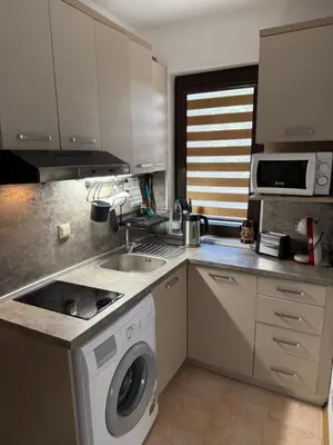 a kitchen with a washing machine and a sink at Sarafovo Sea and Airport Stay in Burgas City
