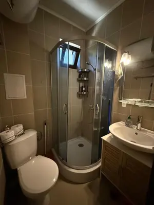 a bathroom with a shower and a toilet and a sink at Sarafovo Sea and Airport Stay in Burgas City