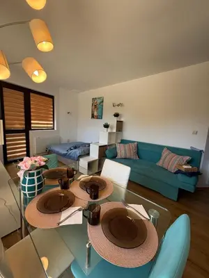 a living room with two tables and a blue couch at Sarafovo Sea and Airport Stay in Burgas City