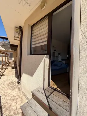 a window on the side of a building with a bench at Sarafovo Sea and Airport Stay in Burgas City