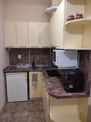 a kitchen with white cabinets and a sink and a microwave at Blue Beach Apartments - Melia in Ravda
