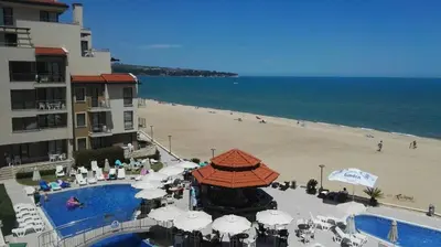 a view of a beach with a hotel and a swimming pool at Panoramic sea view at the beach in Obzor