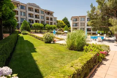 a garden with a lawn in front of a building at Paradise View Guest Apartment in Sozopol