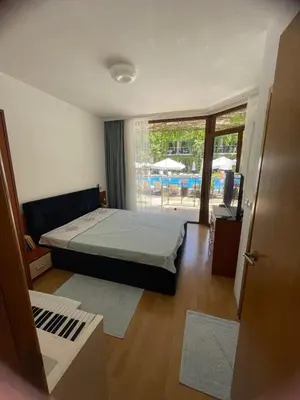 a bedroom with a bed and a view of a pool at Family Paradise in Laguna Beach Hotel in Sozopol