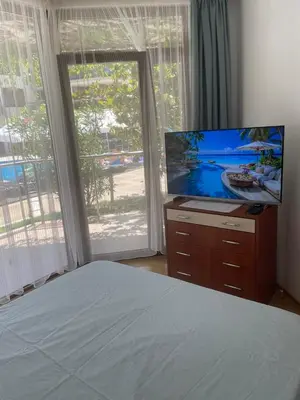 a bedroom with a bed and a flat screen tv at Family Paradise in Laguna Beach Hotel in Sozopol