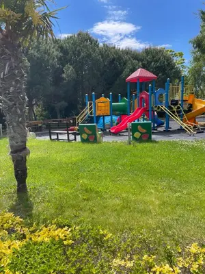 a playground in a park with a grass field at Family Paradise in Laguna Beach Hotel in Sozopol