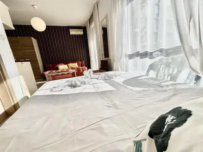 a large white bed in a room with a window at Rainbow 3 - Menada Apartments in Sunny Beach