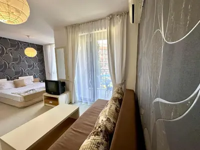 a bedroom with a bed and a tv and a couch at Rainbow 3 - Menada Apartments in Sunny Beach