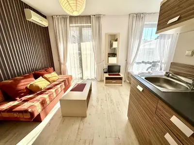 a kitchen and living room with a couch and a sink at Rainbow 3 - Menada Apartments in Sunny Beach