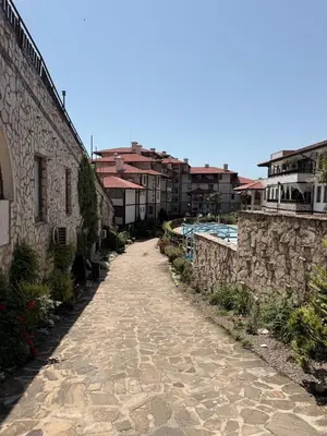a stone path next to a building with a pool at Stylish studio near harbor and luxury beach in Sveti Vlas