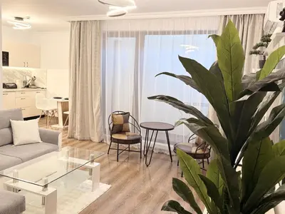 a living room with a couch and a table and a plant at Stylish studio near harbor and luxury beach in Sveti Vlas