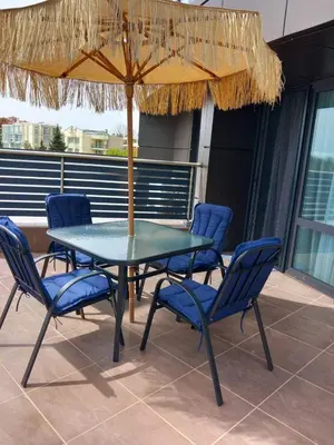 a table and chairs under an umbrella on a patio at Силви Съни Бийч Плаза in Sunny Beach