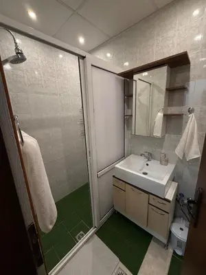 a bathroom with a sink and a shower with a mirror at Pomorie S&T Home in Pomorie