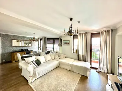 a living room with a white couch and a television at Luxury 3-BR apartment & sky terrace in Sveti Vlas