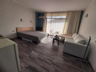 a bedroom with two beds and a couch and a window at Sunshine2 in Sunny Beach
