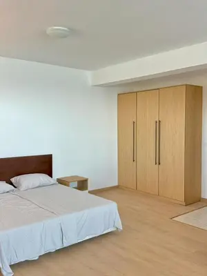 a bedroom with a large bed and wooden cabinets at Byala sea view apartment Studio in Byala