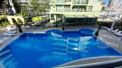 a large blue swimming pool in front of a building at 2 Room Apartment Gallery with Poolview in Sunny Beach