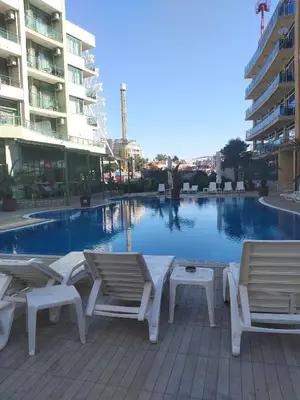 a pool with chaise lounge chairs and a swimming pool at 2 Room Apartment Gallery with Poolview in Sunny Beach
