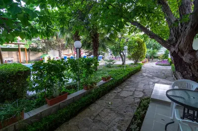 a garden with trees and plants and a stone path at Atlantic Complex Ravda in Ravda