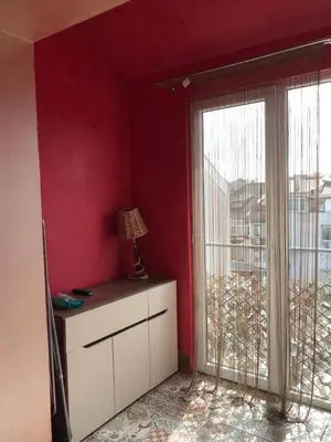 a red room with a window and a dresser with a lamp at Burgas Biju in Burgas City