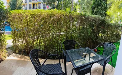 two chairs and a glass table with a teddy bear on it at Monte Carlo Vaio - 1BR Garden Apt - With Direct Pool Access in Sunny Beach