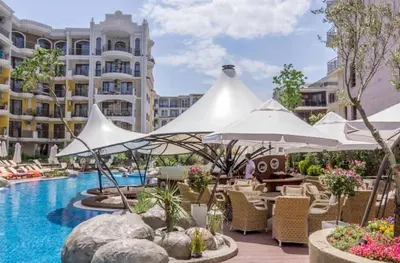a hotel pool with white umbrellas and chairs at Monte Carlo Vaio - 1BR Garden Apt - With Direct Pool Access in Sunny Beach