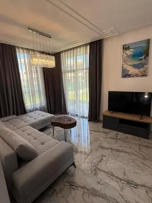 a living room with a couch and a television at Aurum Villas Smokinya Beach 4 in Sozopol