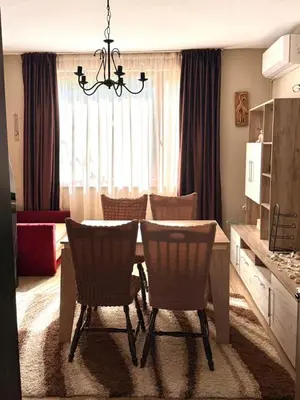 a dining table and chairs in a living room at Apartment in Desi's house in Obzor