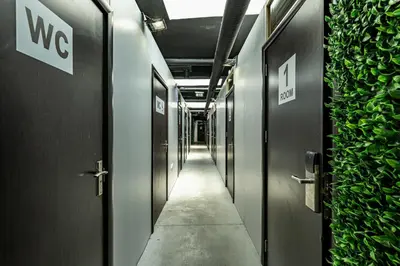 a corridor of a hallway with doors and plants at Heart of the city Hostel in Varna City