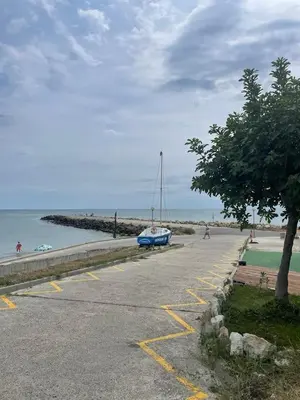 a parking lot next to a beach with a boat at Atlantic in Pomorie