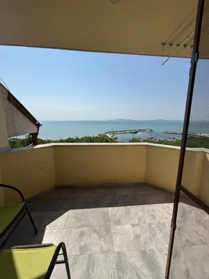 a balcony with an umbrella and a view of the ocean at Стаи за гости Денкови in Burgas City
