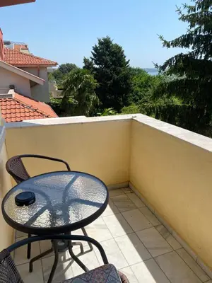a patio with a table and chairs on a balcony at Стаи за гости Денкови in Burgas City