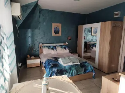 a bedroom with a bed and a blue wall at Studio Juli in Lozenets