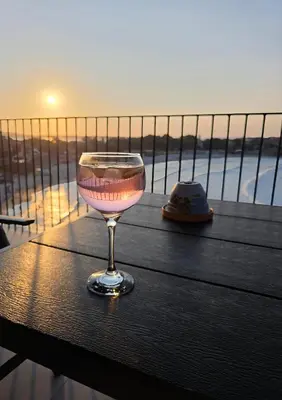 a glass of wine sitting on top of a table at Магията на Созо in Sozopol