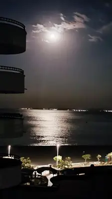 a view of the ocean at night with the moon at Luxurious Apartment with sea view in Pomorie