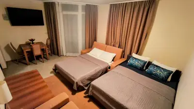 a hotel room with two beds and a desk at Luxurious Apartment with sea view in Pomorie