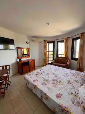 a bedroom with a bed and a couch and a television at Windmill Nessebar studio with sea view in Nesebar